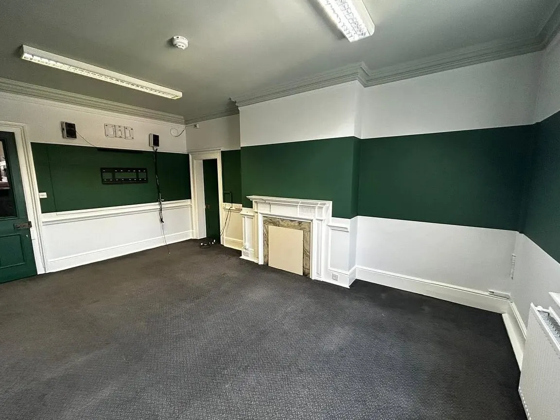 Hotel room decorated in green and white with panelling