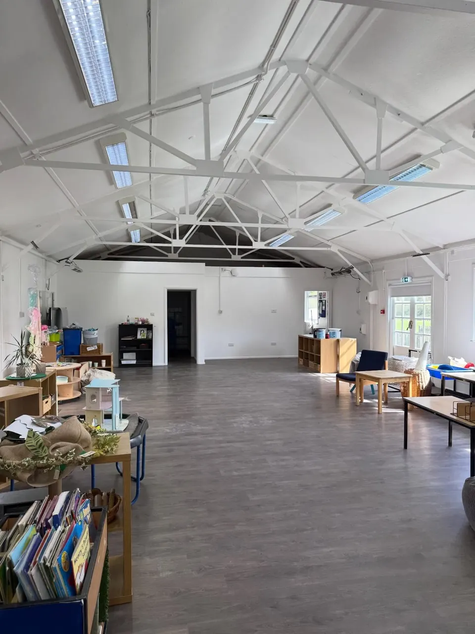 Commercial room with exposed white roof trusses