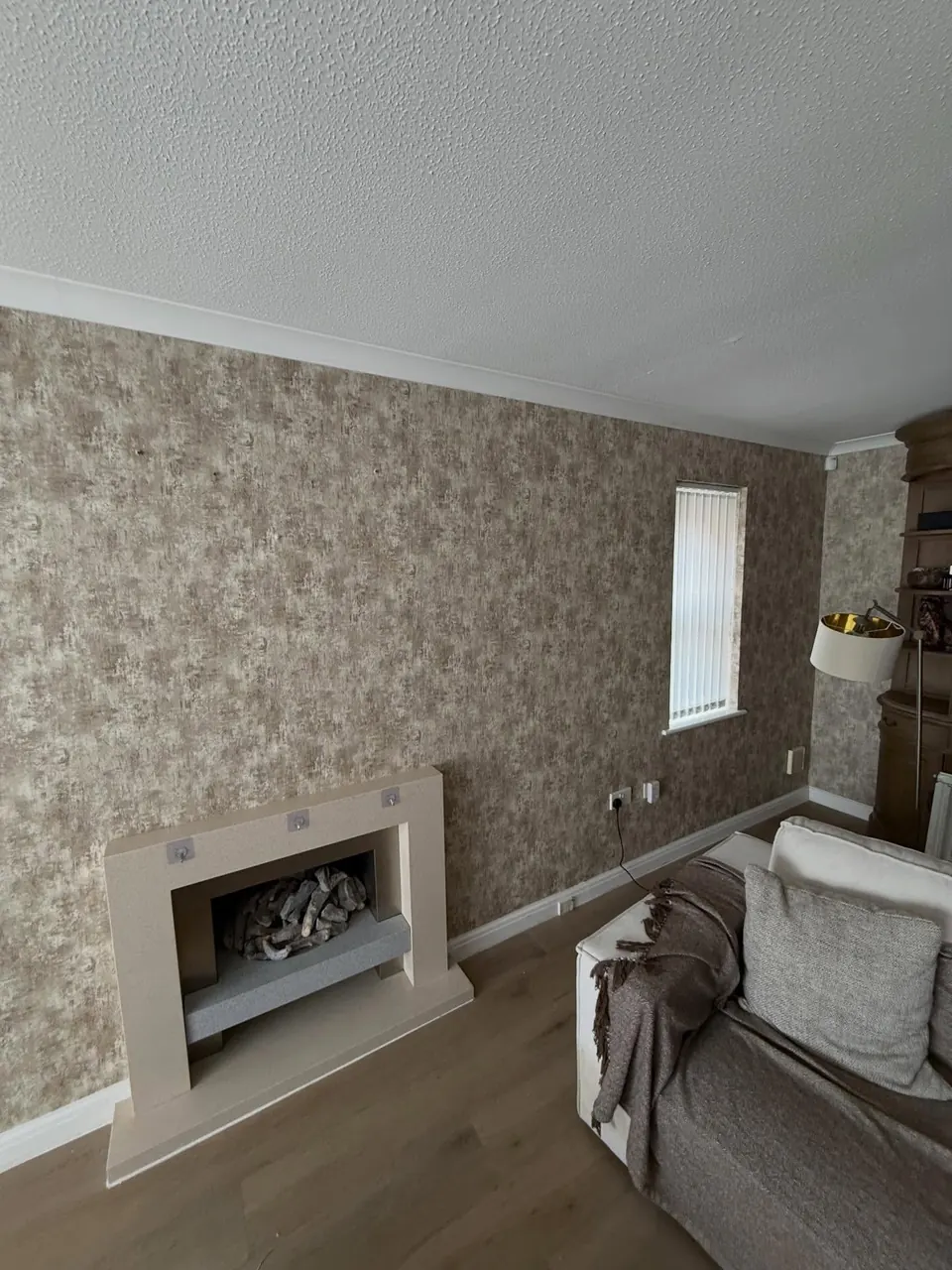 Textured bronze-effect wallpaper around a fireplace