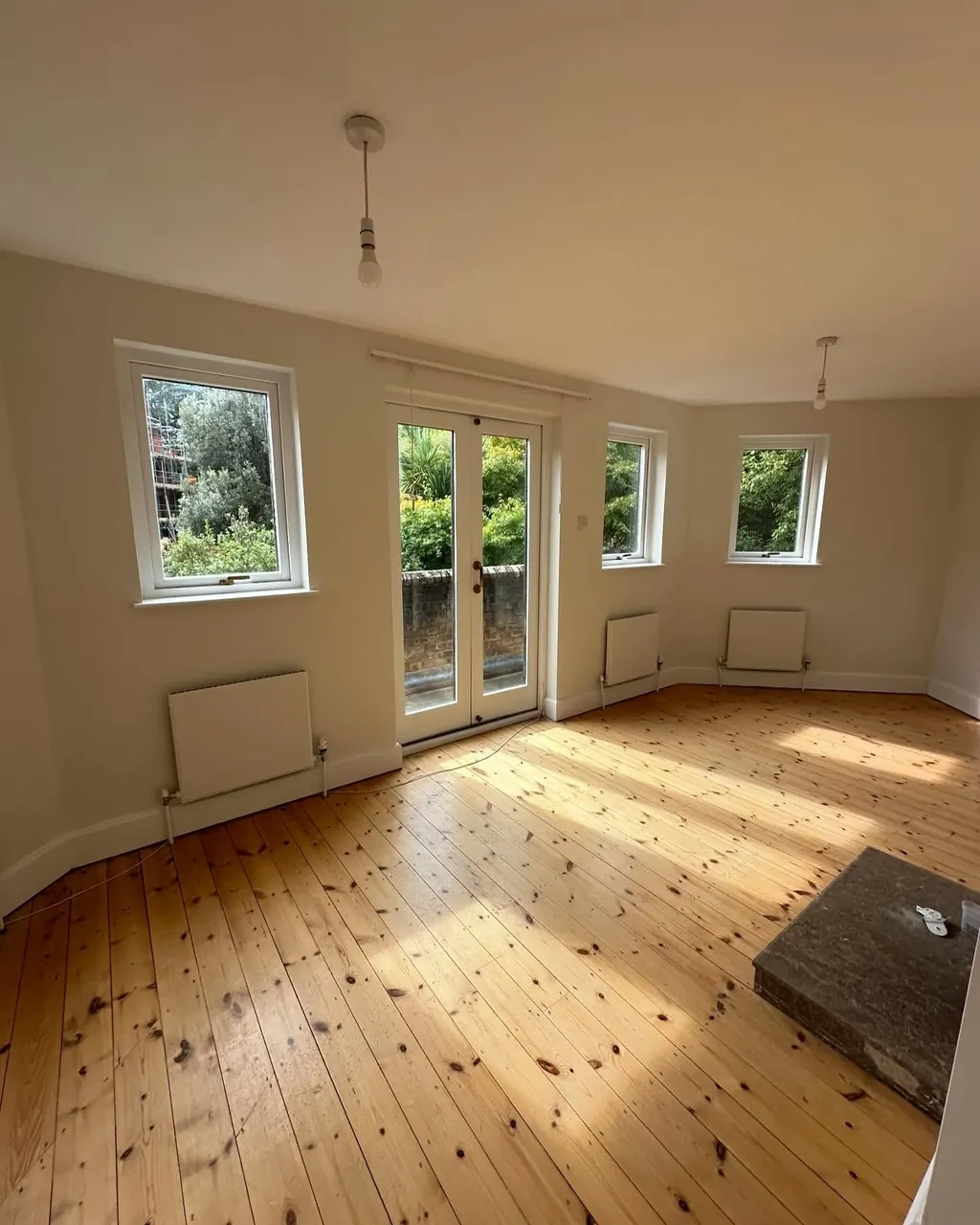 Bright empty room painted in pale tones with wooden floorboards