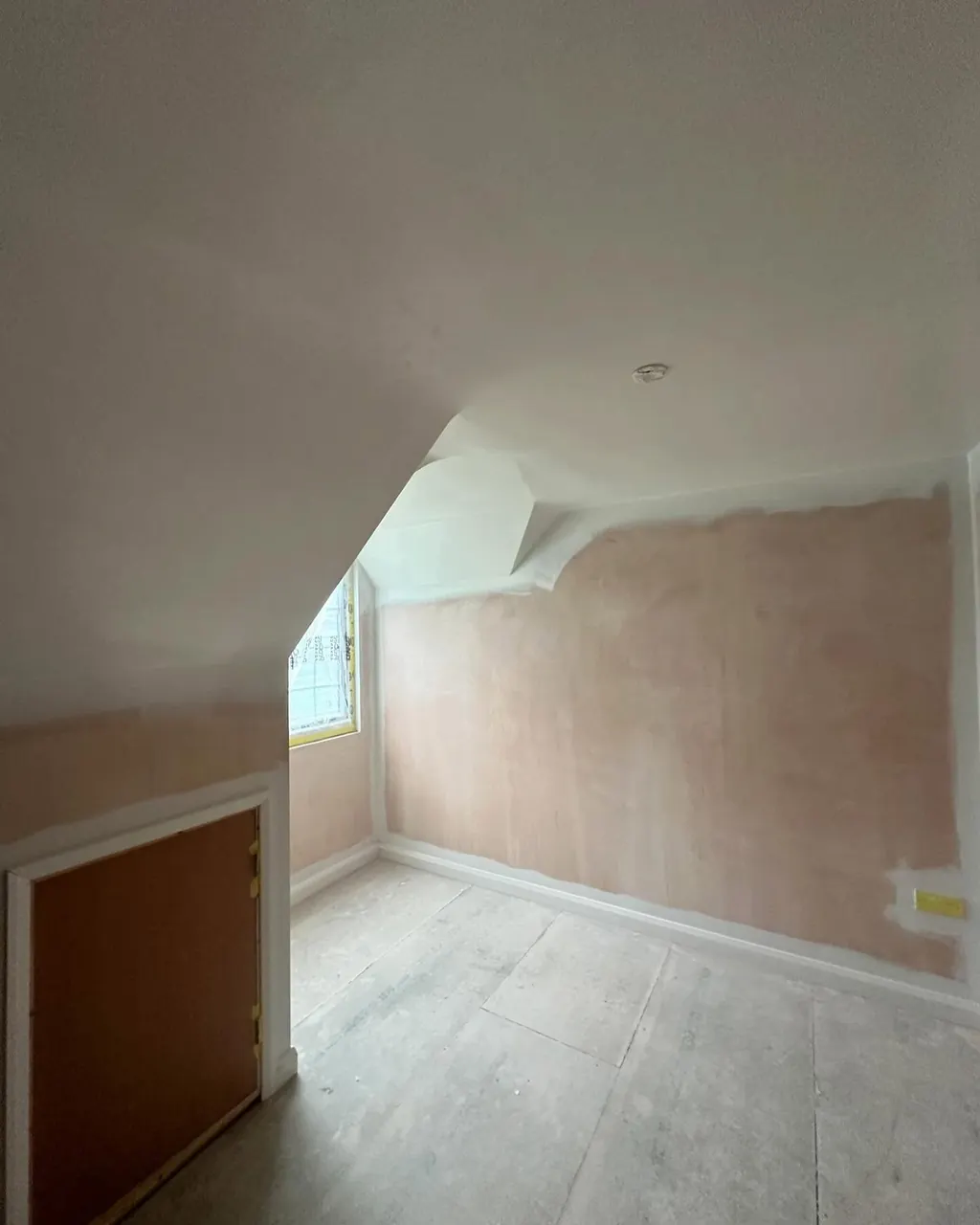 Attic room with bare plaster before interior painting