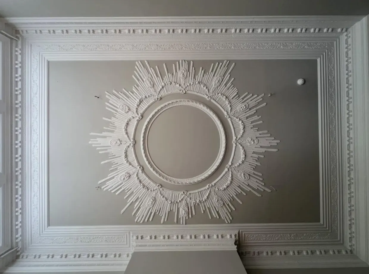 Close-up of a freshly painted ornate ceiling rose and coving