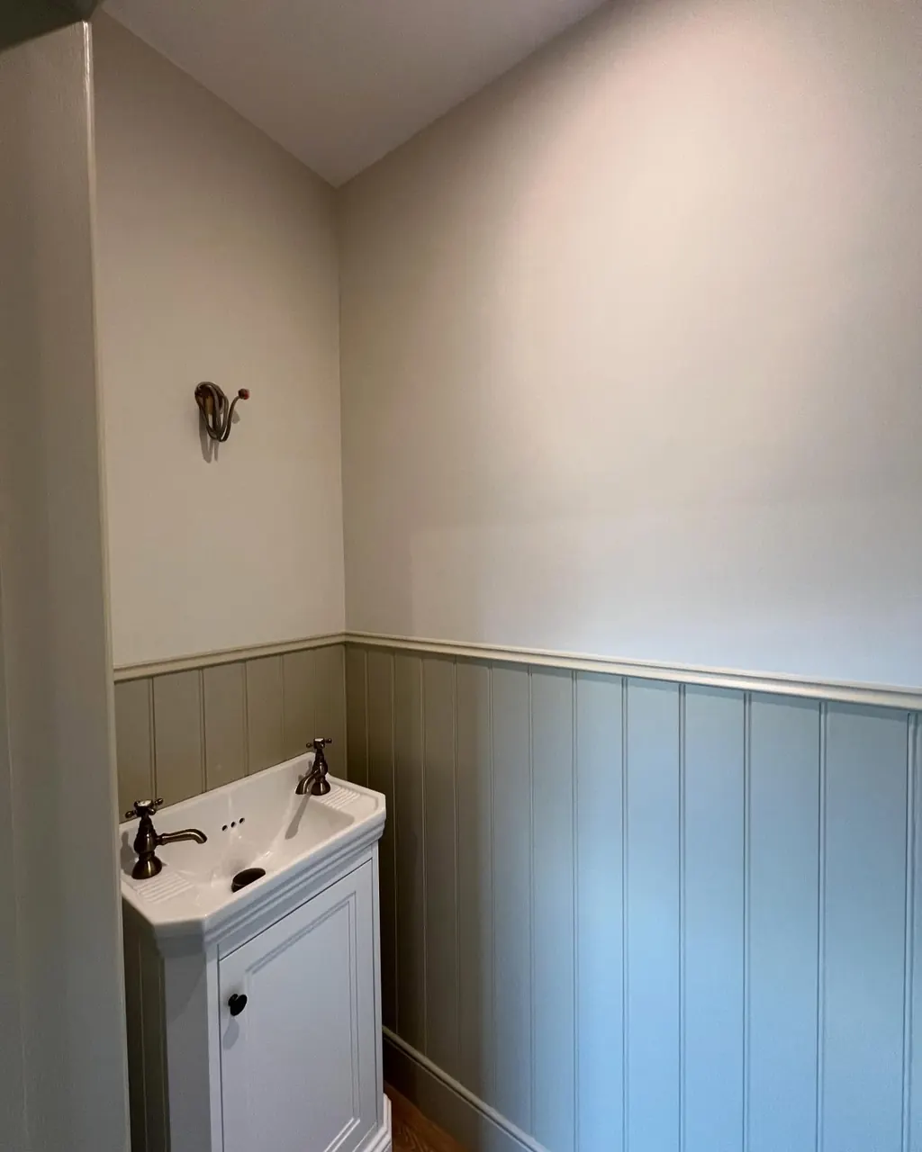 Tongue-and-groove panelling painted sage in a cloakroom