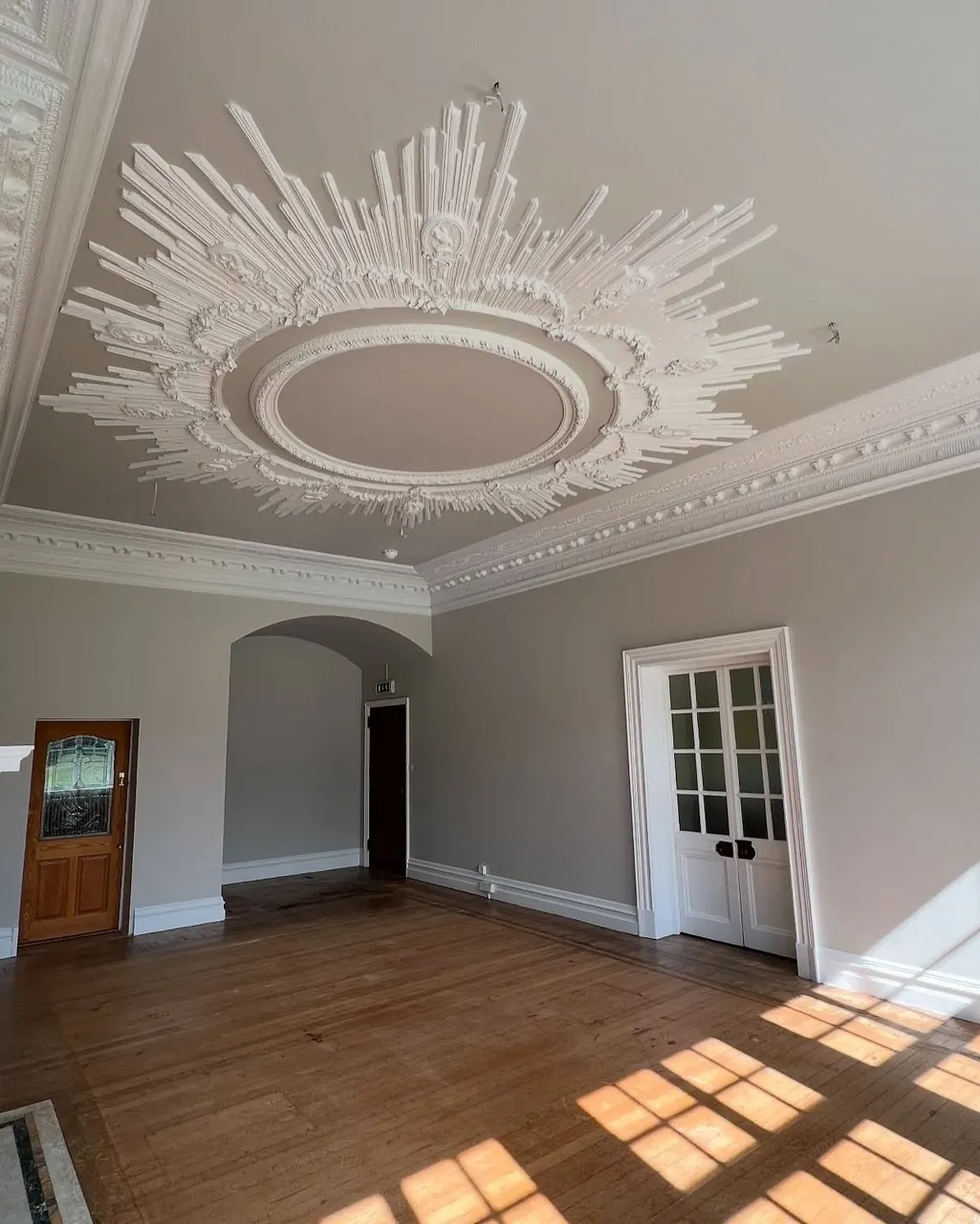 Period room with decorative ceiling and wood floor after painting