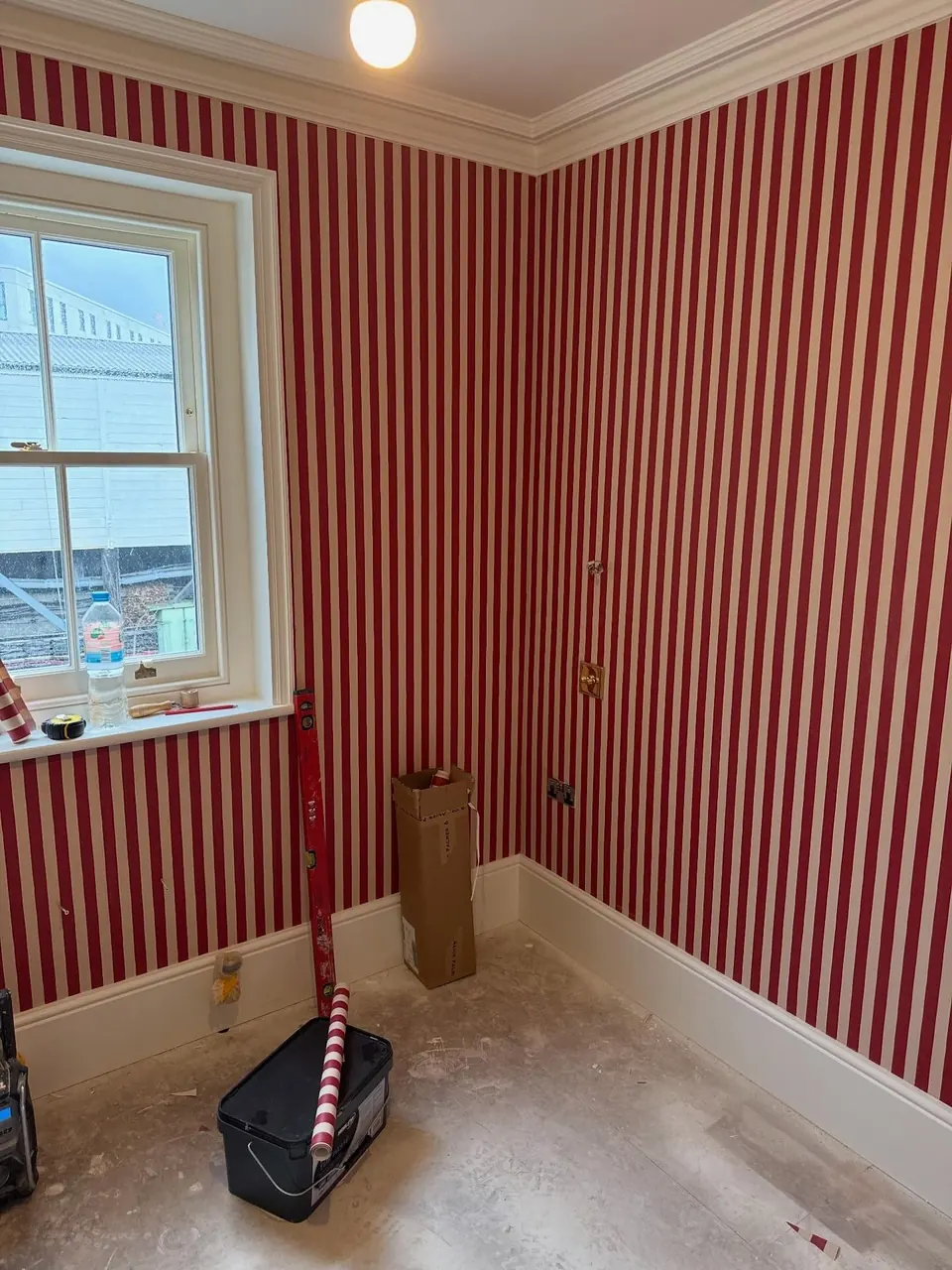 Striped wallpaper hung around a sash window