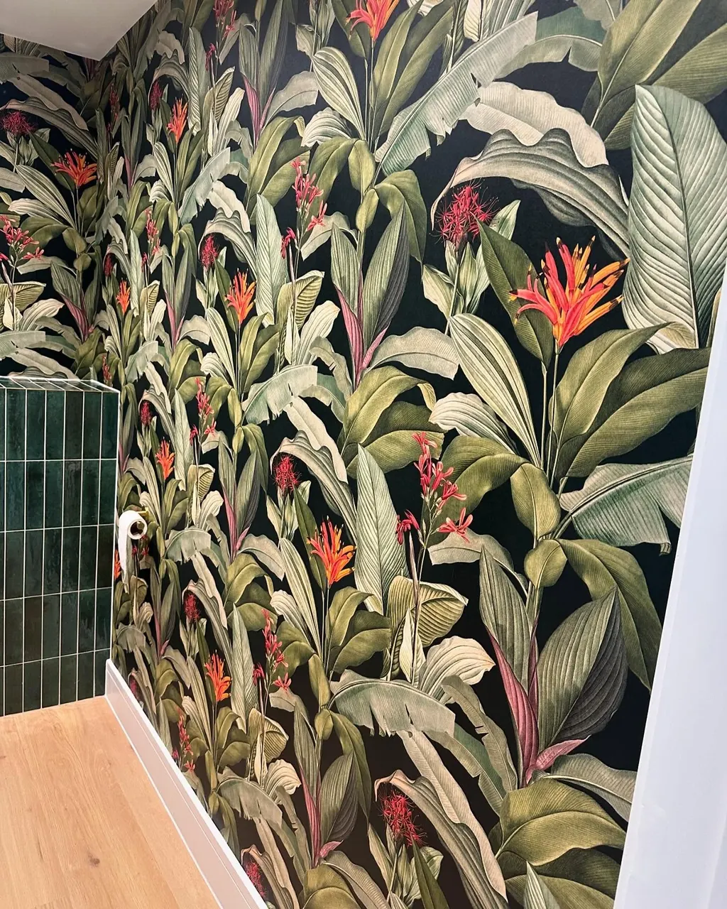 Pattern-matched botanical wallpaper across a cloakroom wall