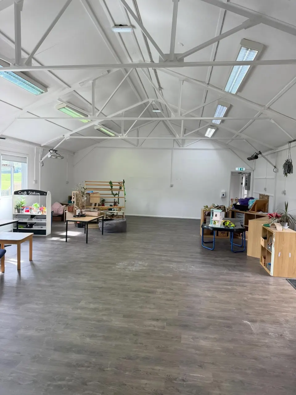 Bright commercial room with painted exposed roof trusses