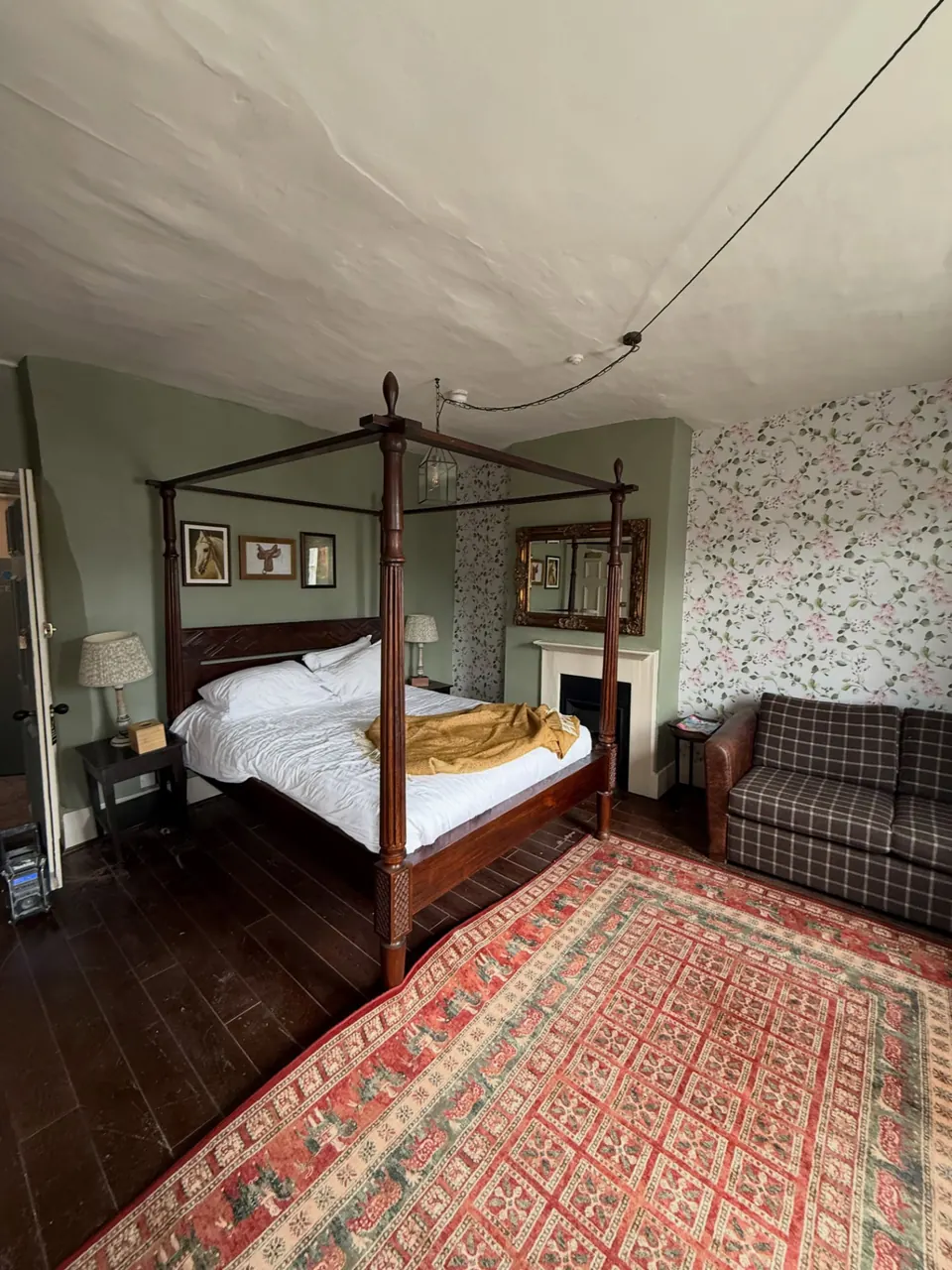 Four-poster bedroom with patterned wallpaper and green walls