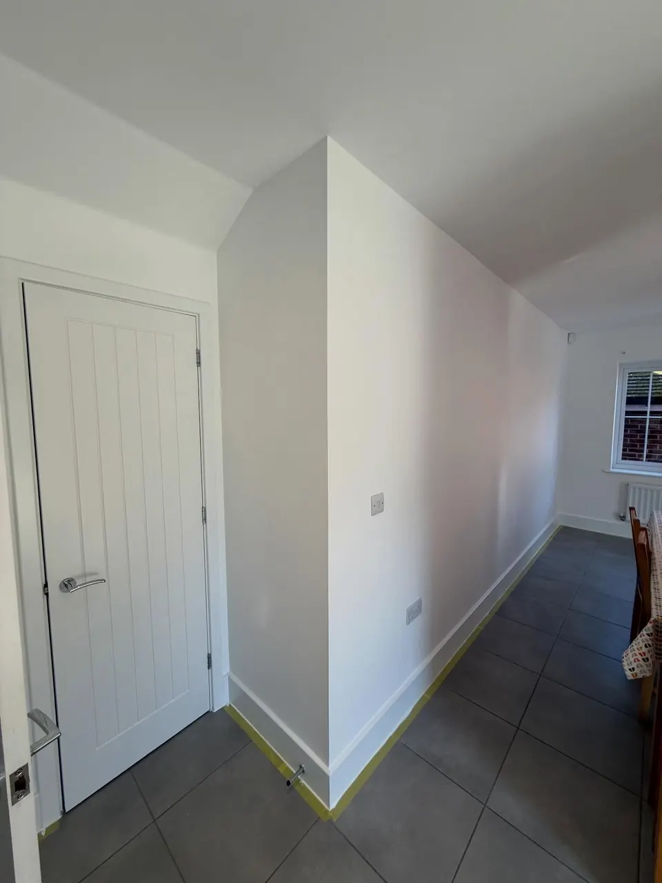 Crisp white walls and skirting painted in a kitchen-diner