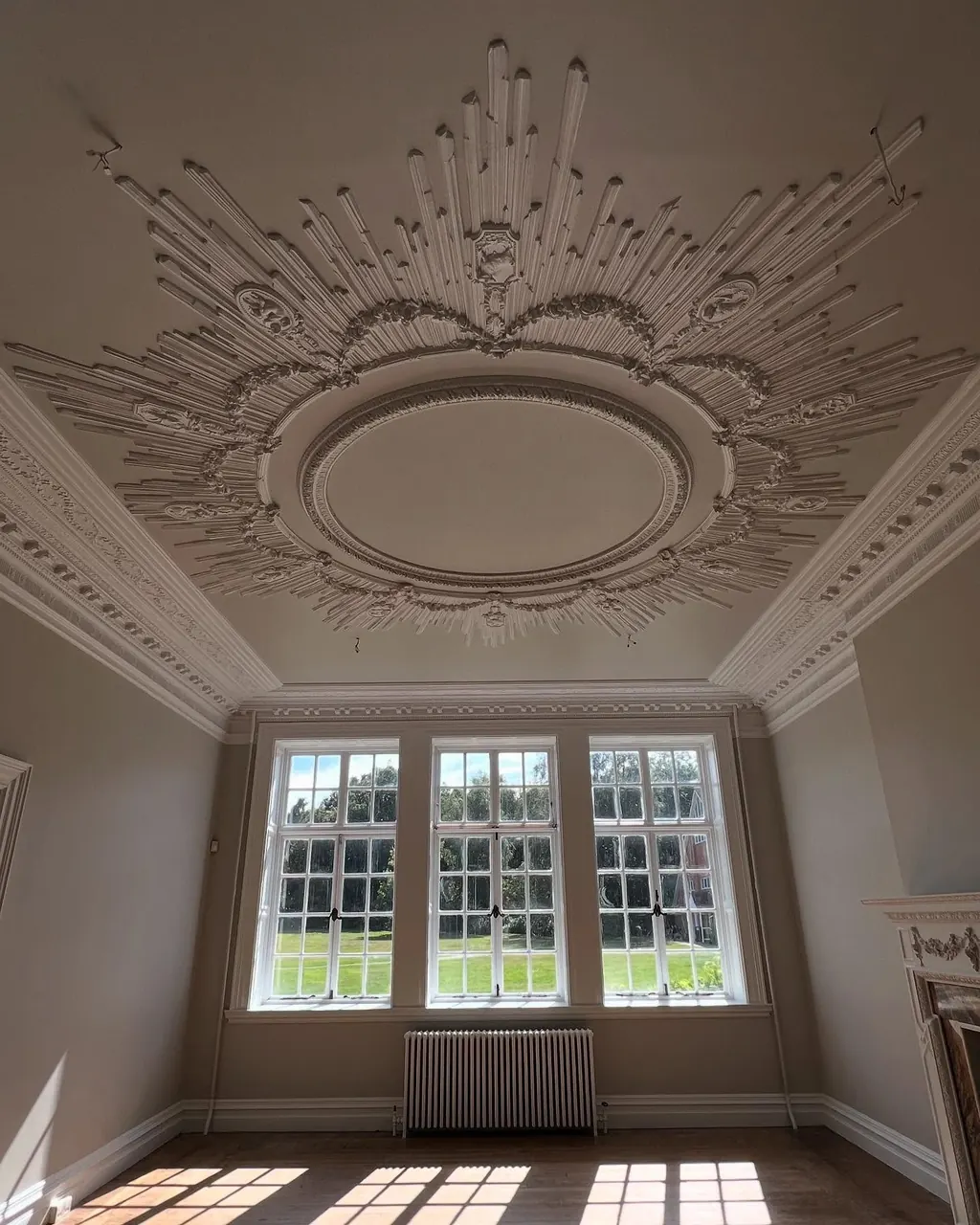 Room with ceiling rose and tall windows after redecoration