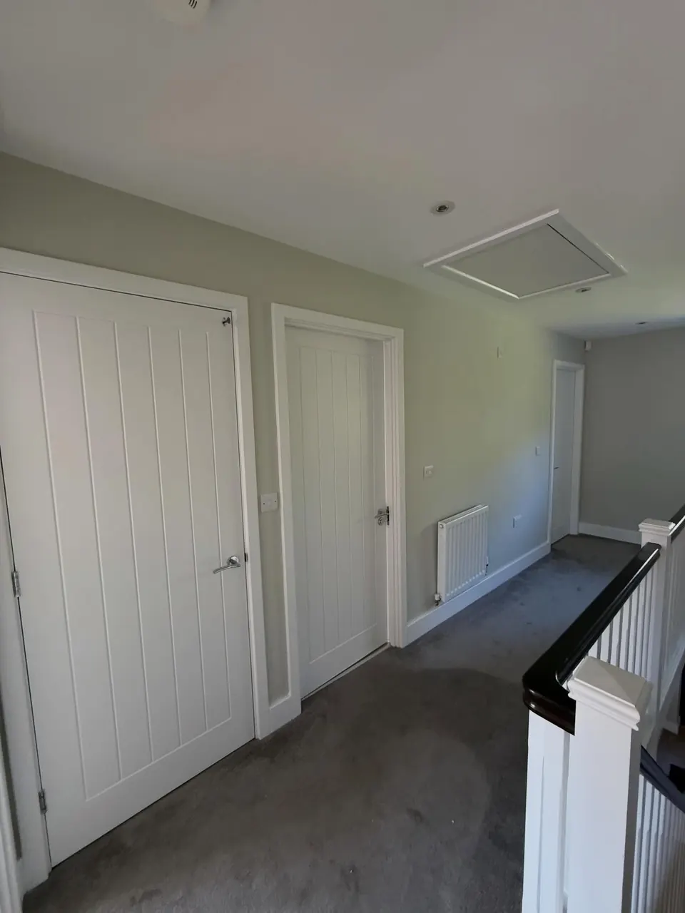 Landing decorated with pale walls and white painted doors