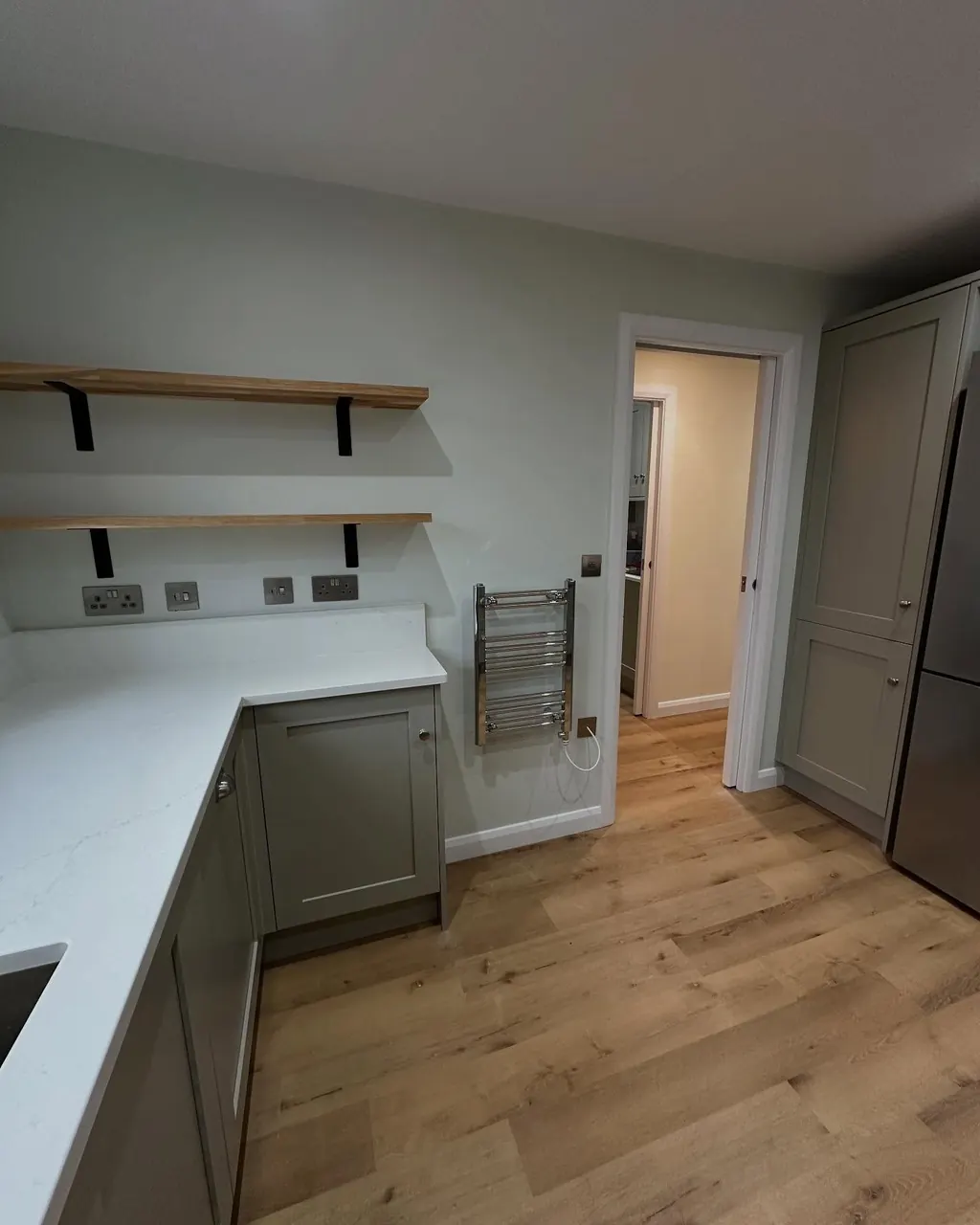 Kitchen with freshly painted walls and grey-green units