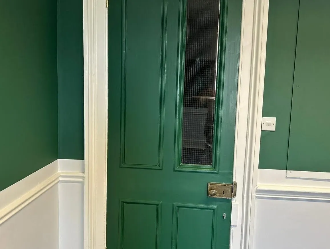 Green painted door and white trim in a commercial building