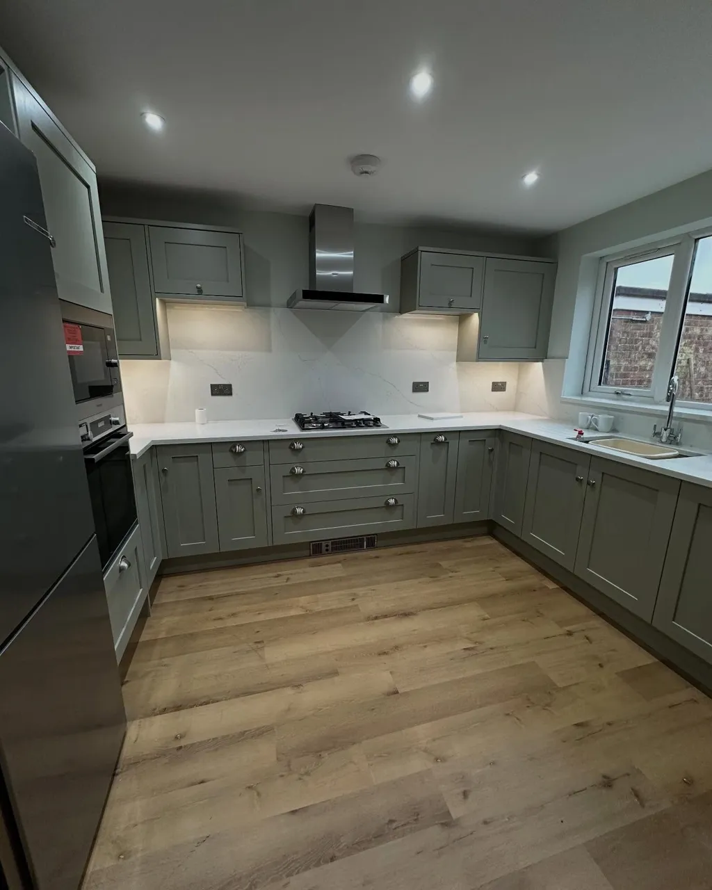Shaker kitchen cabinets painted sage green by Centurion Decorating