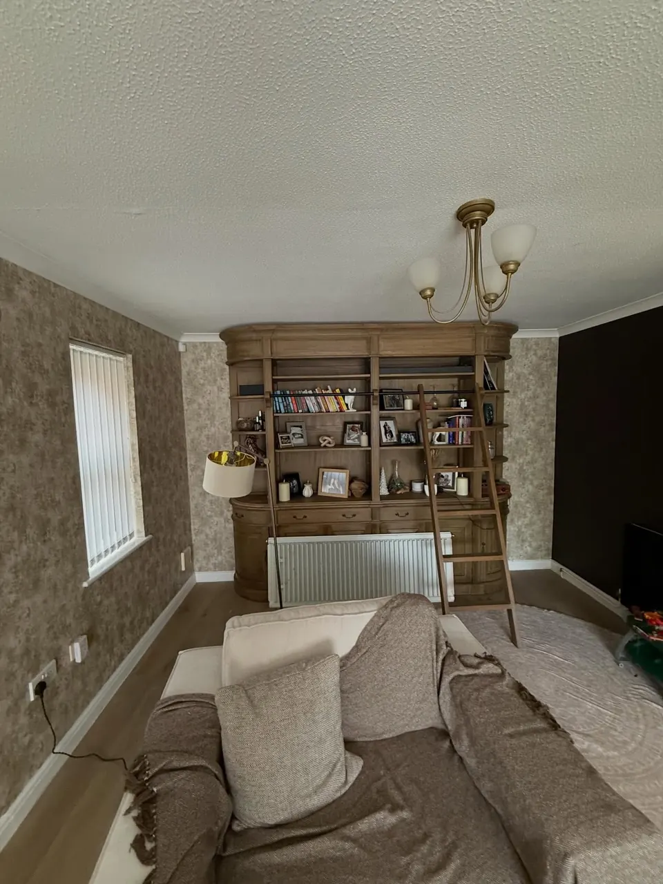 Living room walls wallpapered in a textured metallic finish